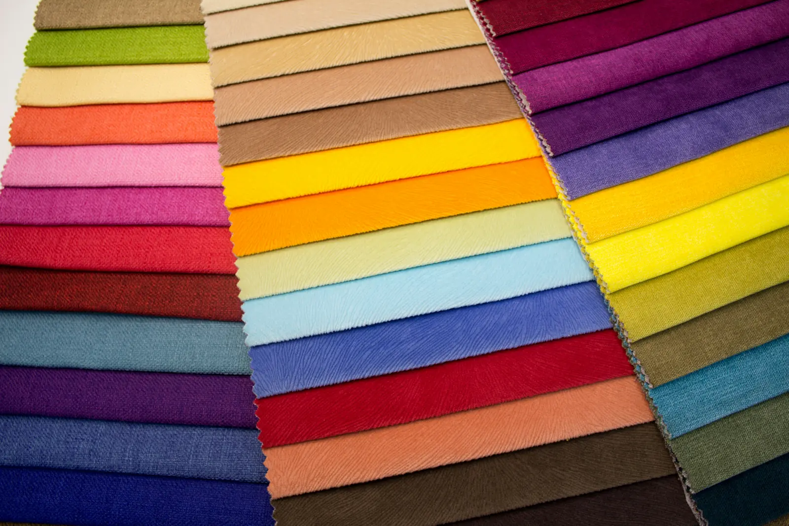 Fabric swatch cards fanned out showing dyed colour options across three quality ranges